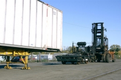 Yard hostler rolls bogie under loaded RailRunner chassis